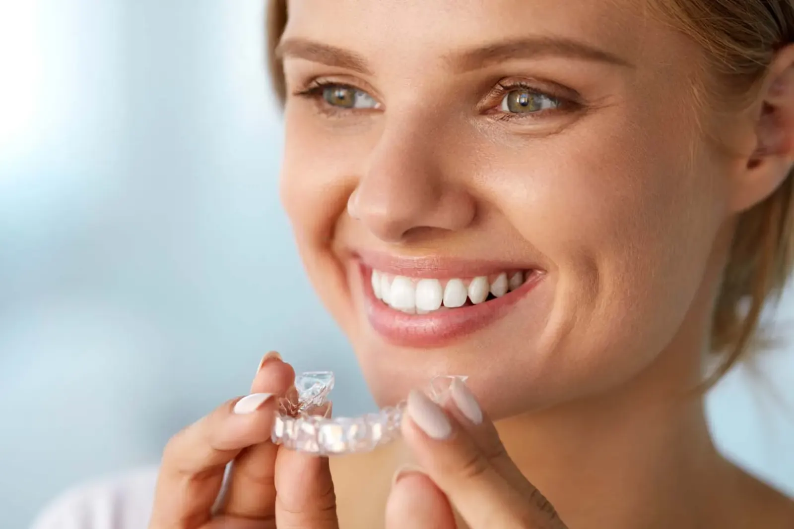Patient holding an Invisalign clear aligner